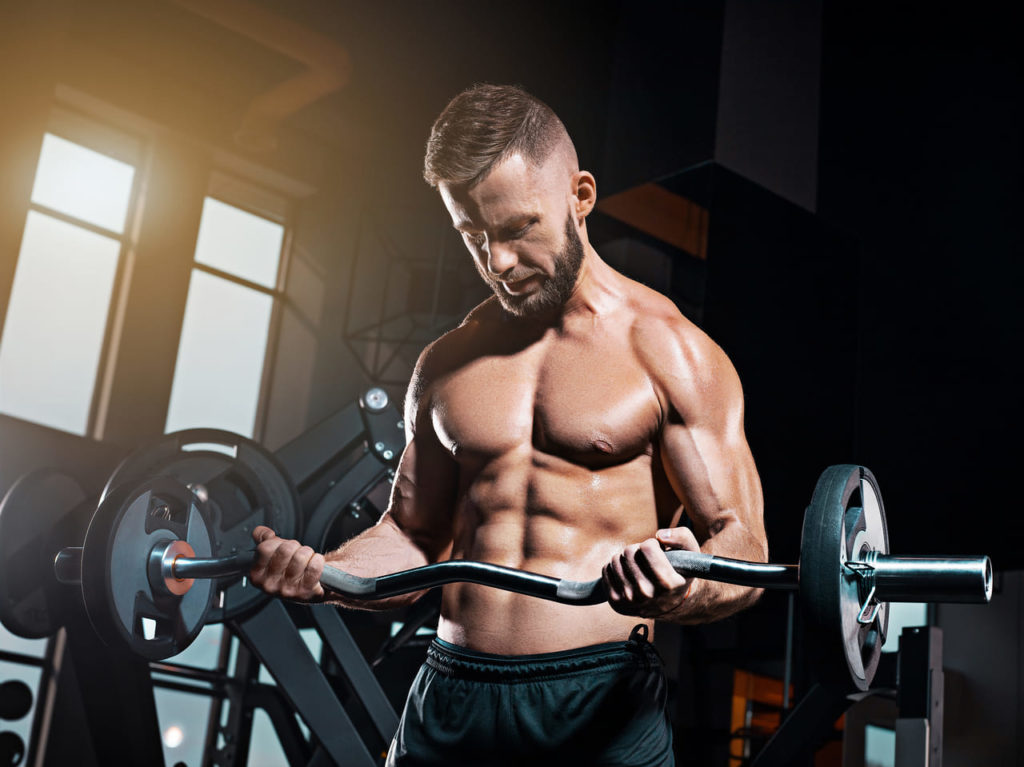 portrait-of-super-fit-muscular-young-man-working-out-in-gym-with-barbell